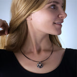 Fine silver origami pendant by Azulie, intricate hexagon design with a soft gunmetal patina, set with a Japanese pale pink pearl, on a black stainless steel multi-strand necklace, shown on model